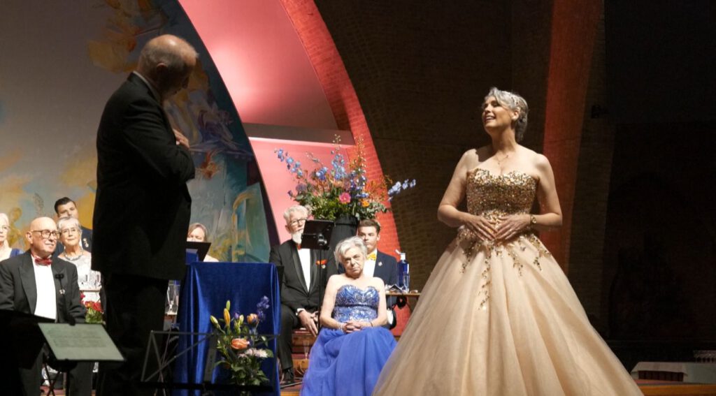Soliste in gouden galajurk zingt solo tijdens het openingsconcert van Koor Wilhelmina in de Sacramentskerk Breda.